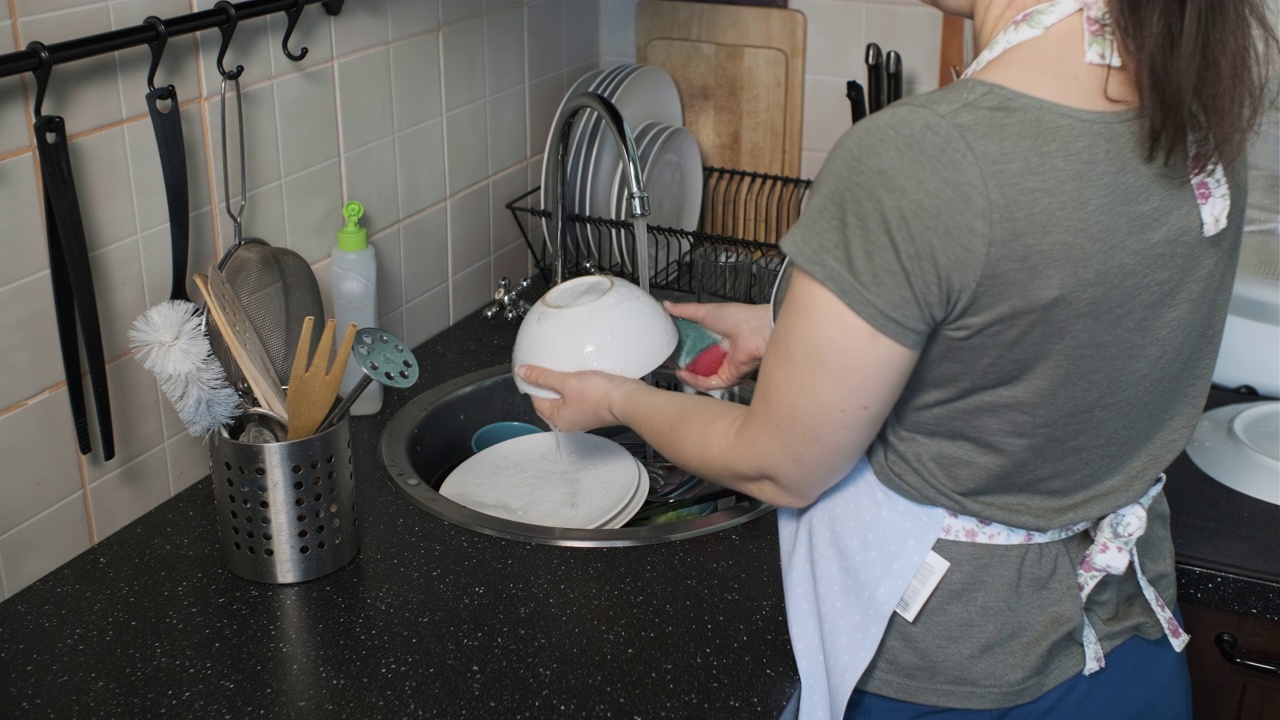 女性用海绵在水槽里洗碗视频素材