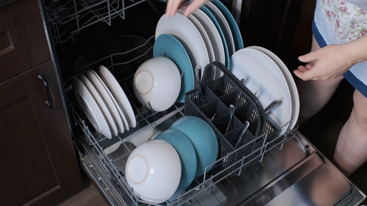 家庭主妇把盘子放进洗碗机视频素材