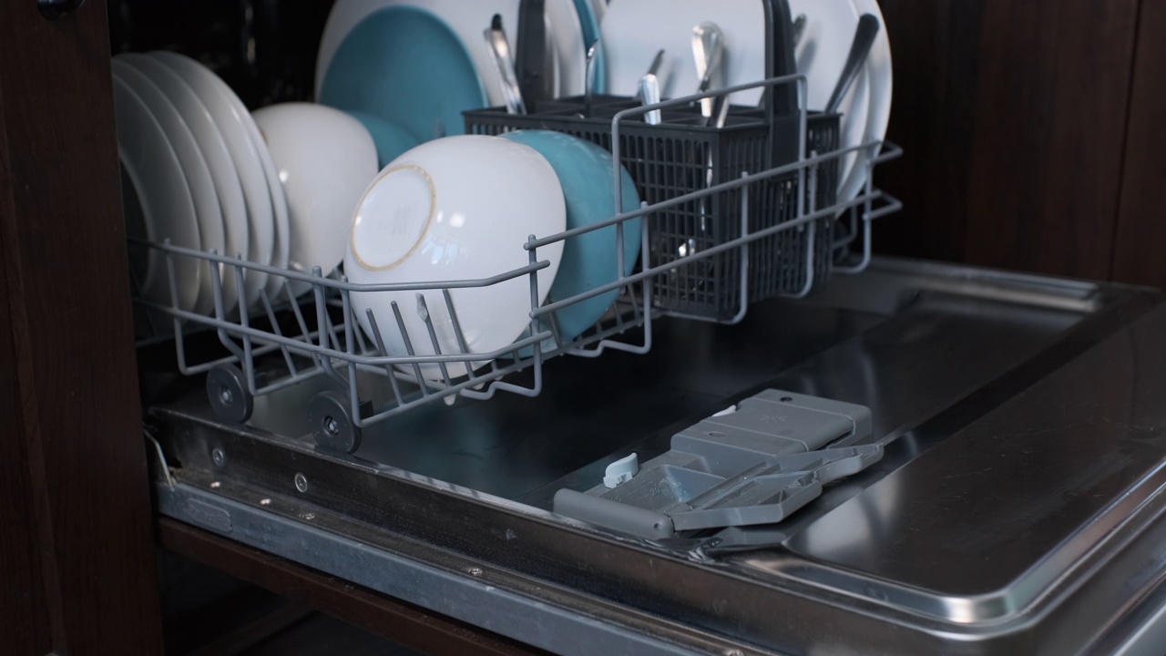 女人把洗洁精片放进洗碗机视频素材