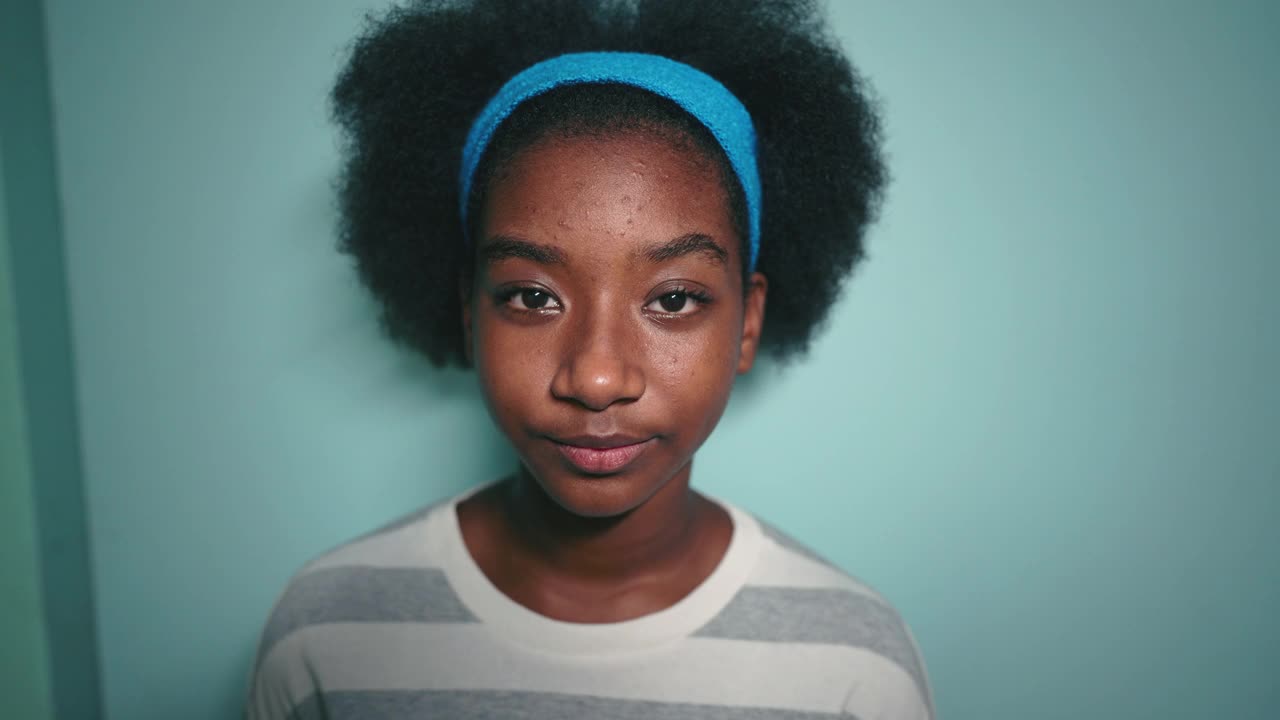 非洲发型女孩的肖像看着相机，工作室拍摄视频素材