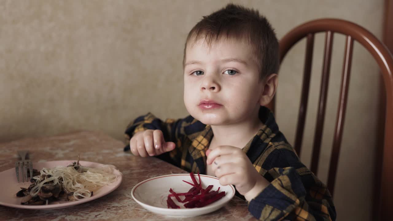 一个孩子在厨房里用手吃甜菜根视频下载