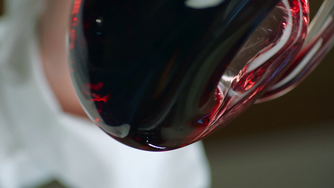 侍酒师将红酒从瓶中倒入酒瓶。近距离镜头的葡萄酒混合过程在水瓶。葡萄酒的准备过程。拍摄在红色氦电影摄影机慢动作。视频素材