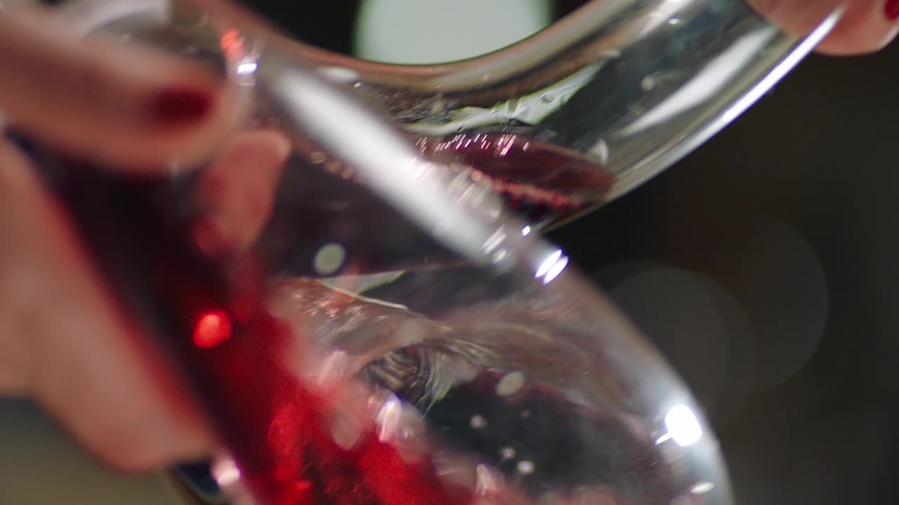 侍酒师将红酒从瓶中倒入酒瓶。近距离镜头的葡萄酒混合过程在水瓶。葡萄酒的准备过程。拍摄在红色氦电影摄影机慢动作。视频素材