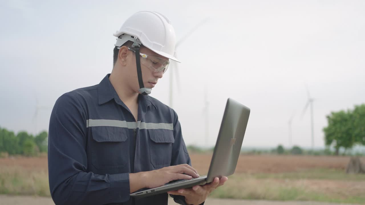 检查工程师准备和进度检查与笔记本电脑的风力涡轮机的安全在风电场在泰国。视频素材