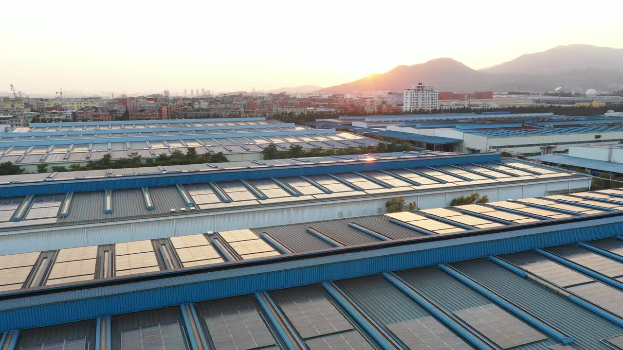 太阳落山时，太阳能电池板安装在一家大型工厂的屋顶上的航拍照片视频素材