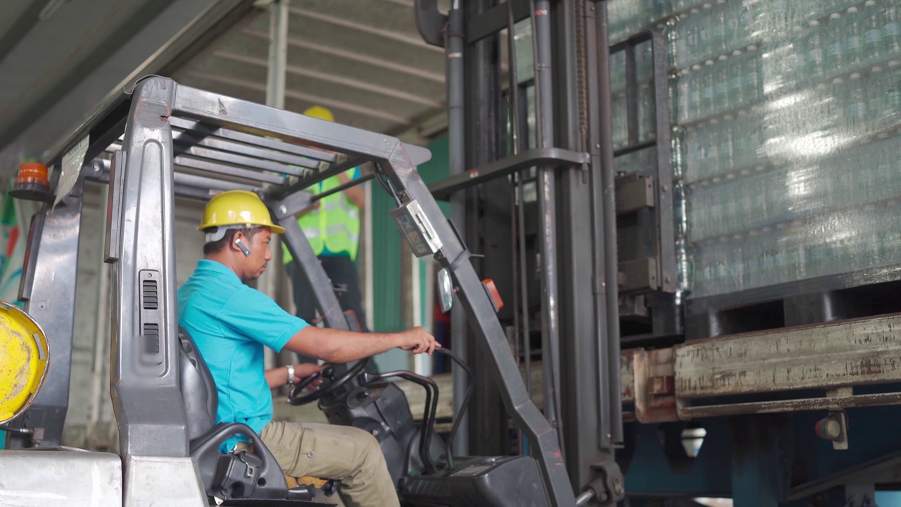 亚洲仓库工人用叉车将纸箱装到托盘上，领班清点存货视频素材
