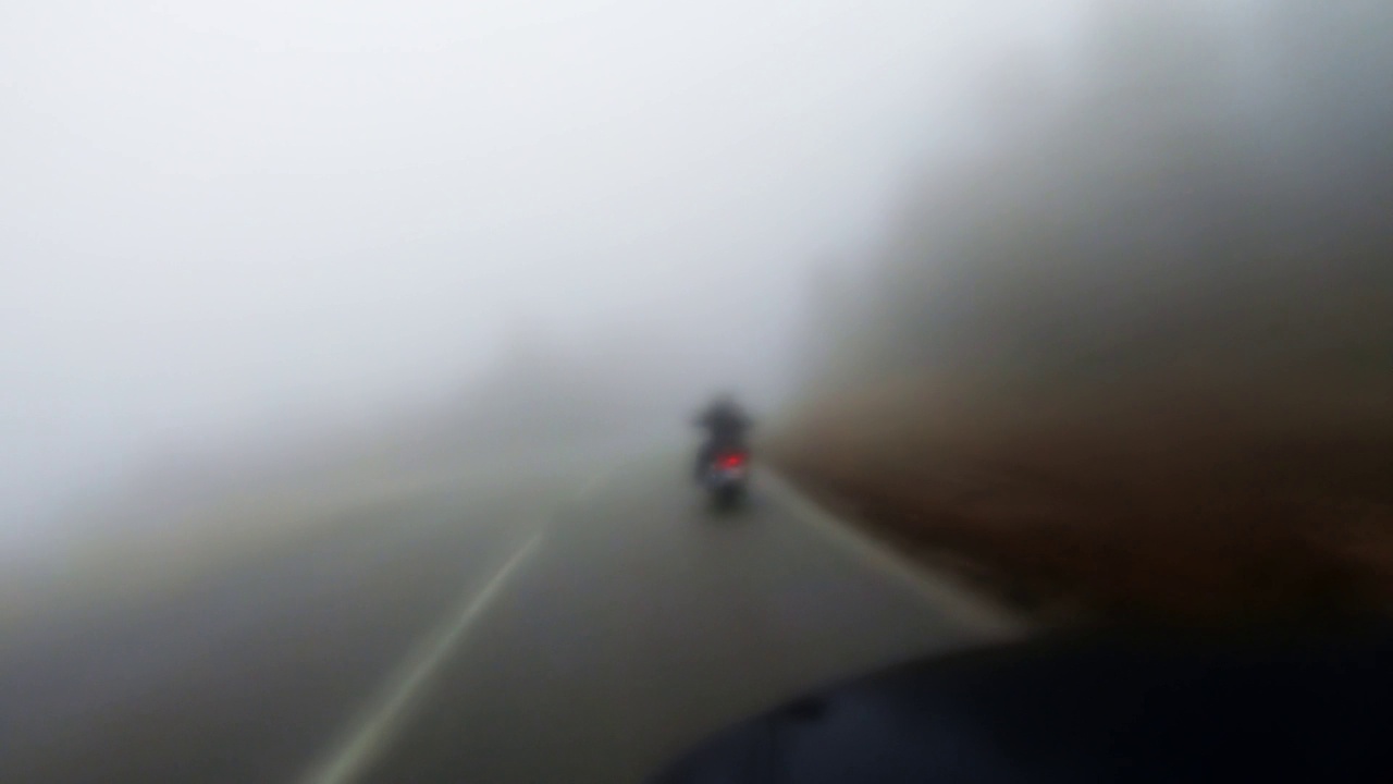 雾中骑摩托车的人在雾中骑摩托车的镜头散焦视频素材