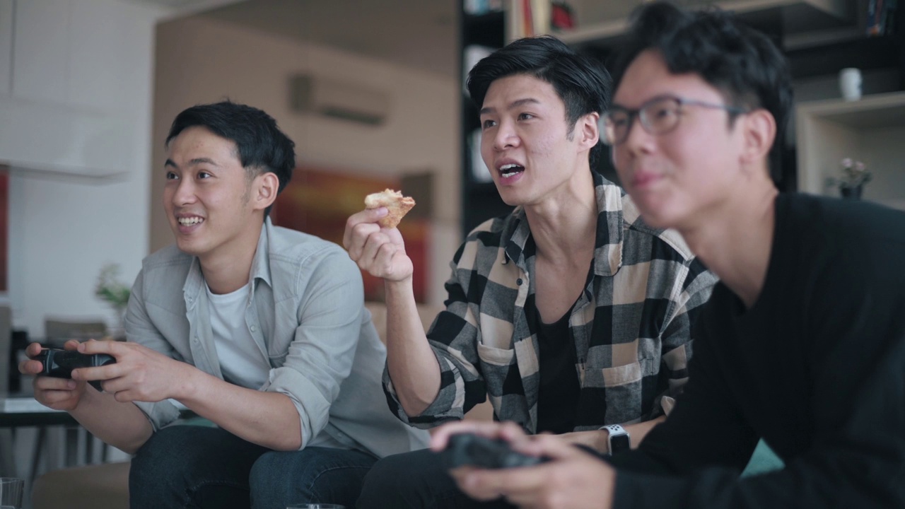 亚洲的中国年轻人喜欢在周末和他的朋友在客厅玩电子游戏视频下载