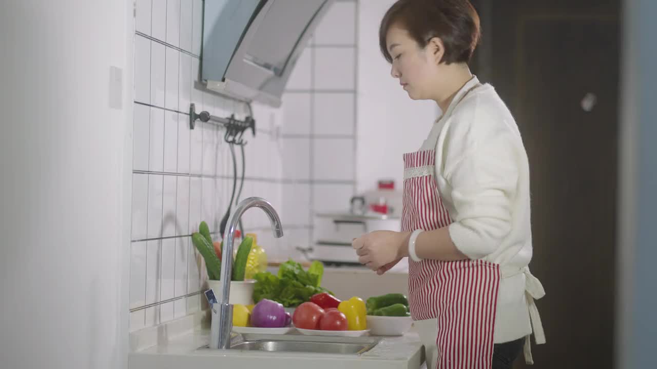 女人在厨房里洗菜视频素材
