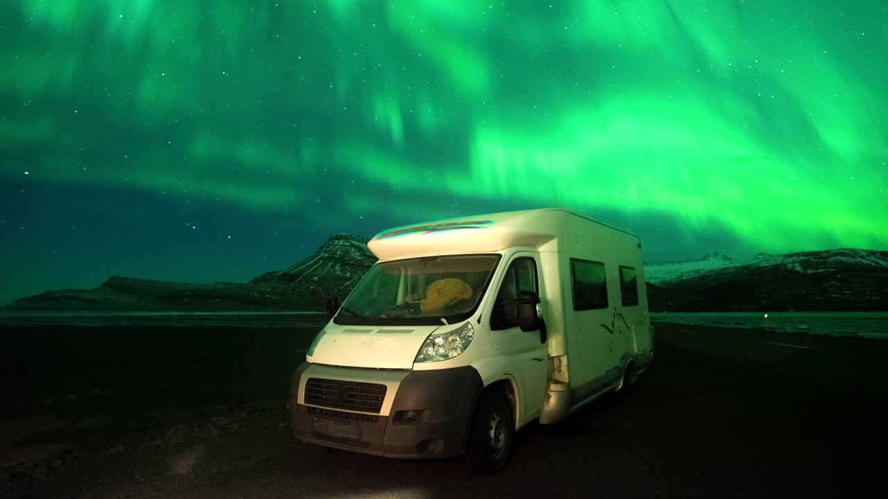 在冰岛的汽车公园里，4K时间推移的北极光与房车公园视频下载