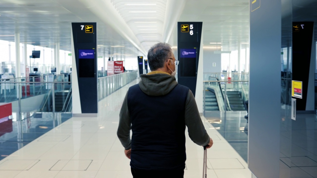 乘客带着带轮的旅行袋穿过机场候机楼视频素材