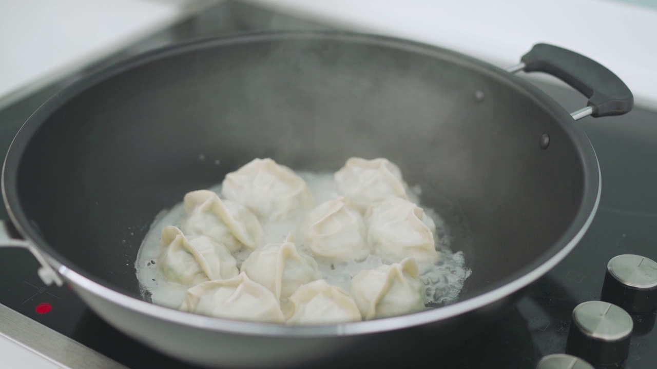 近距离的中国奶奶准备煮蒸汽中国饺子在烹饪锅在itchen视频下载
