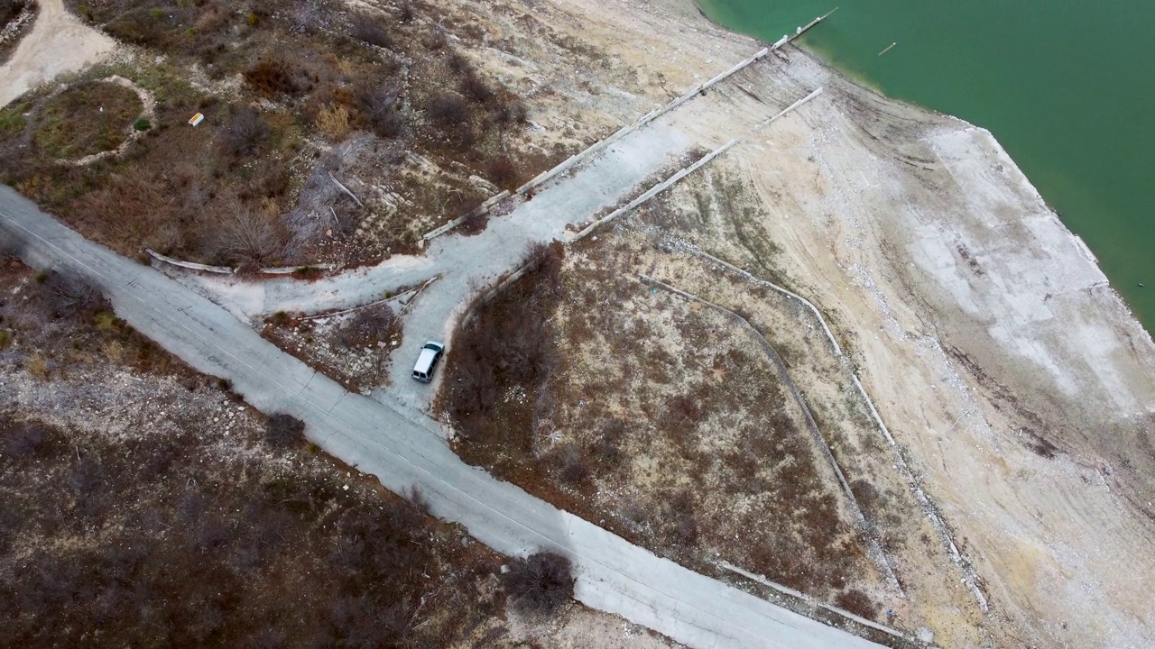 一个受干旱影响的水库的海岸线鸟瞰图，有一条通往海岸线的道路。视频下载