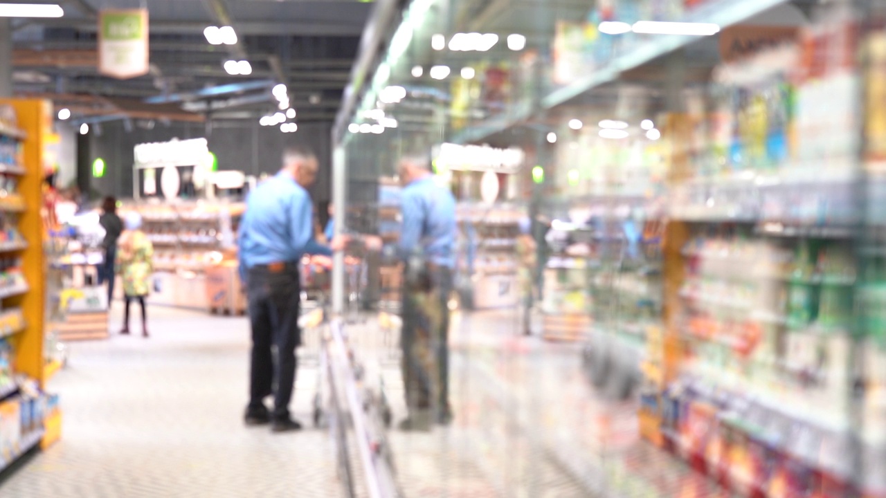 一位男性购物者进入超市寻找食品视频素材