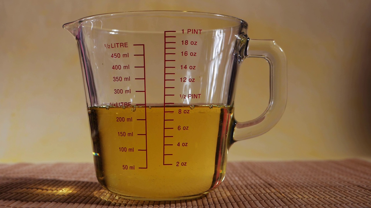 测量玻璃罐与植物油的特写镜头视频下载