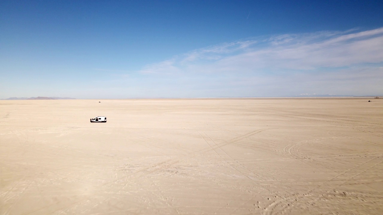两名男子驾驶着一辆时髦的空中定制露营车驶近犹他州西北部靠近内华达州温德沃的博纳维尔盐滩视频下载