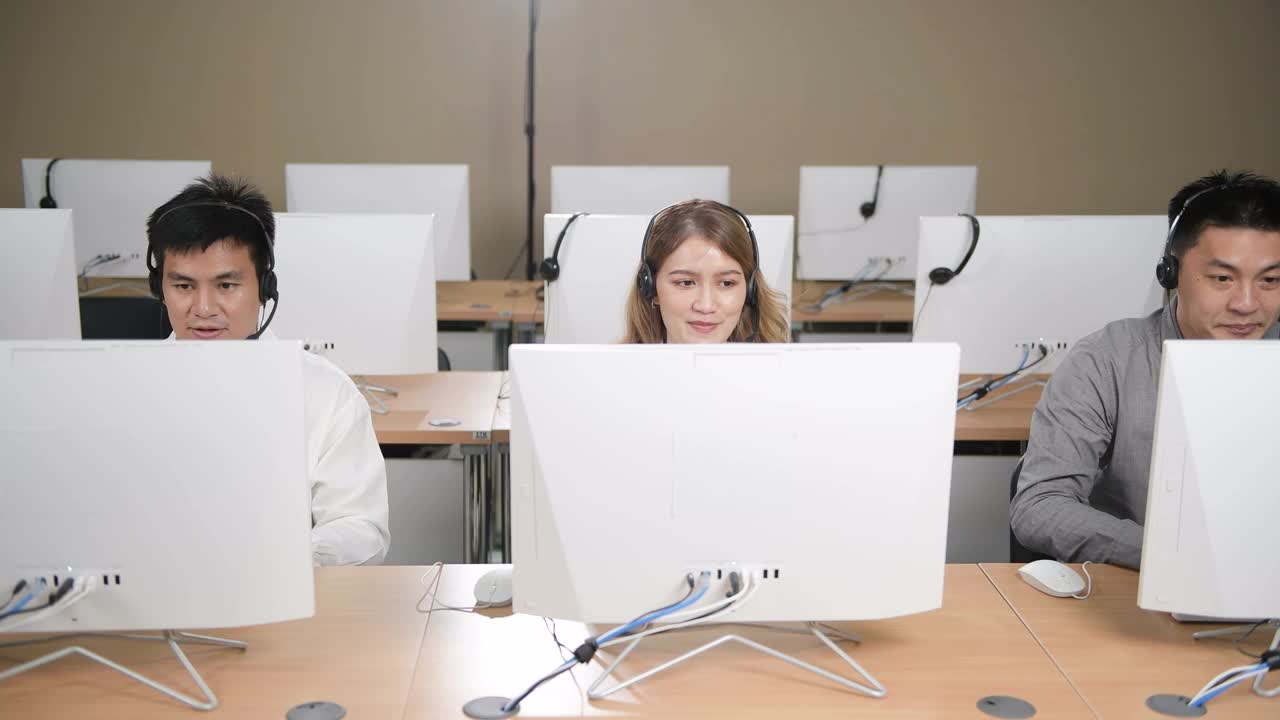 呼叫中心和客户服务。使用台式电脑在电脑桌和电话线在现代共同工作视频下载