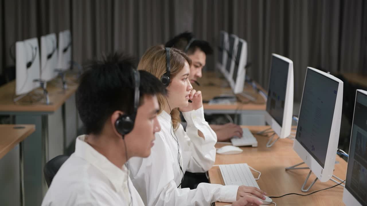 呼叫中心和客户服务。使用台式电脑在电脑桌和电话线在现代共同工作视频下载