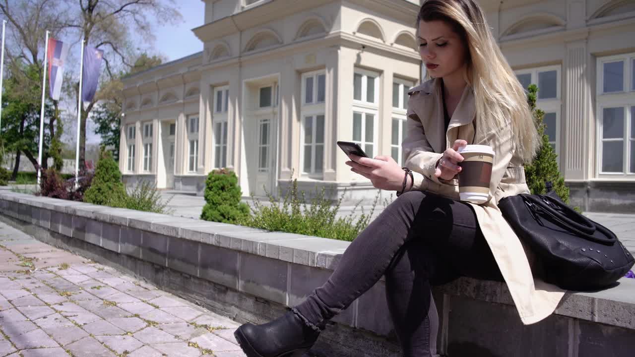 女人在户外放松，喝咖啡，发短信视频下载