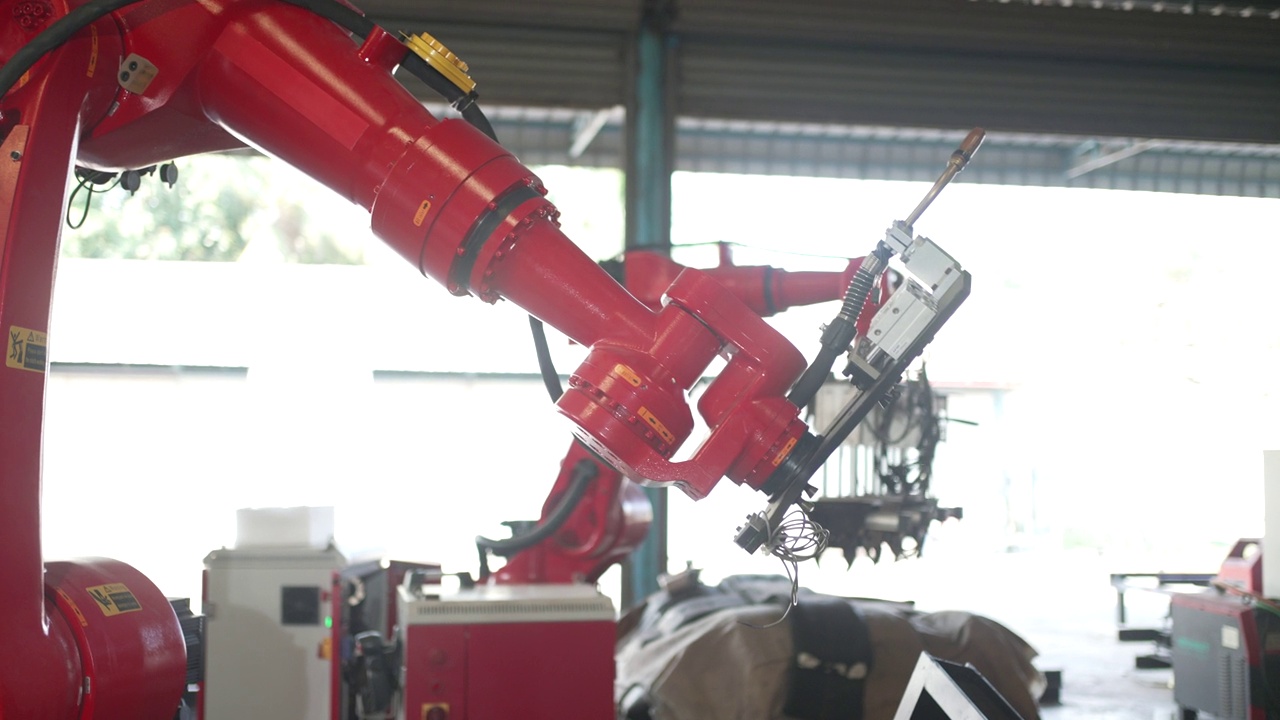 工人们在工厂里用机械手臂工作。视频素材