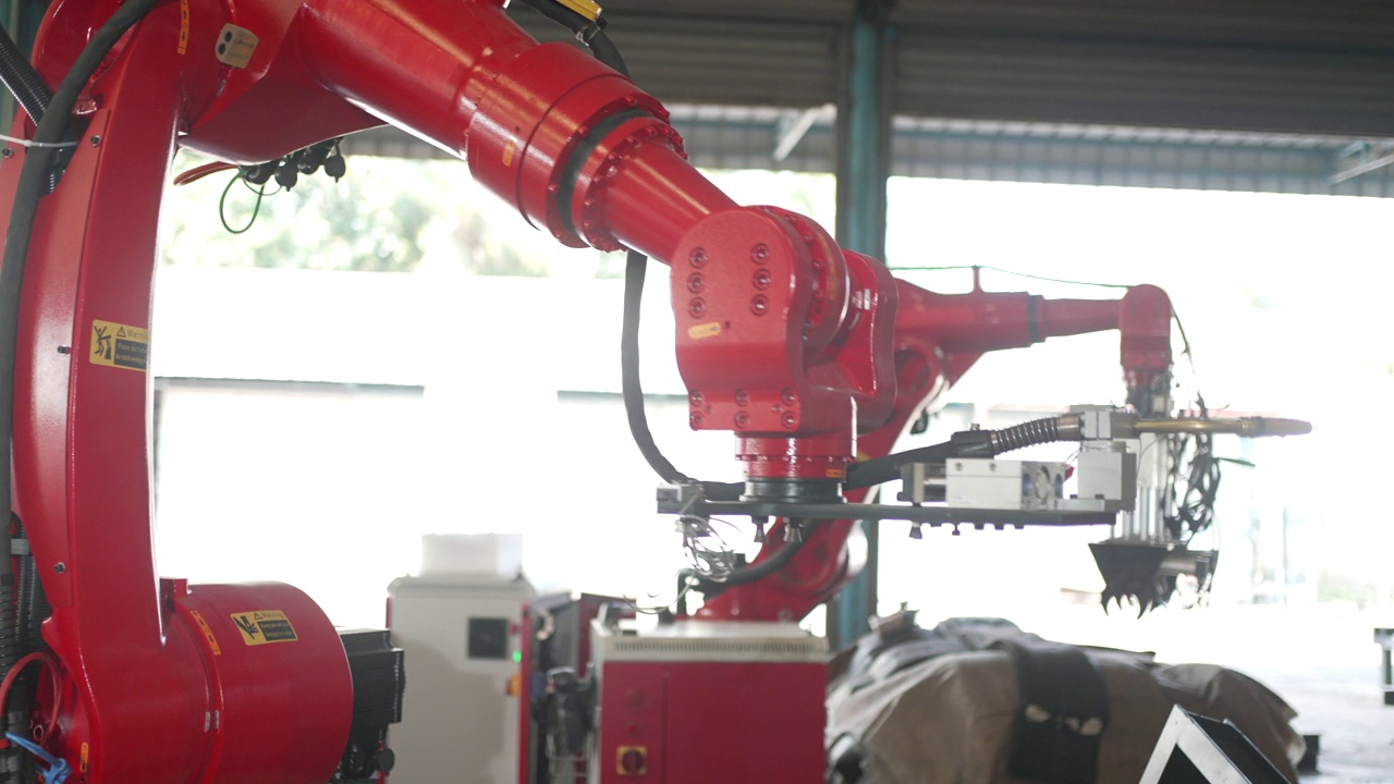 工人们在工厂里用机械手臂工作。视频素材