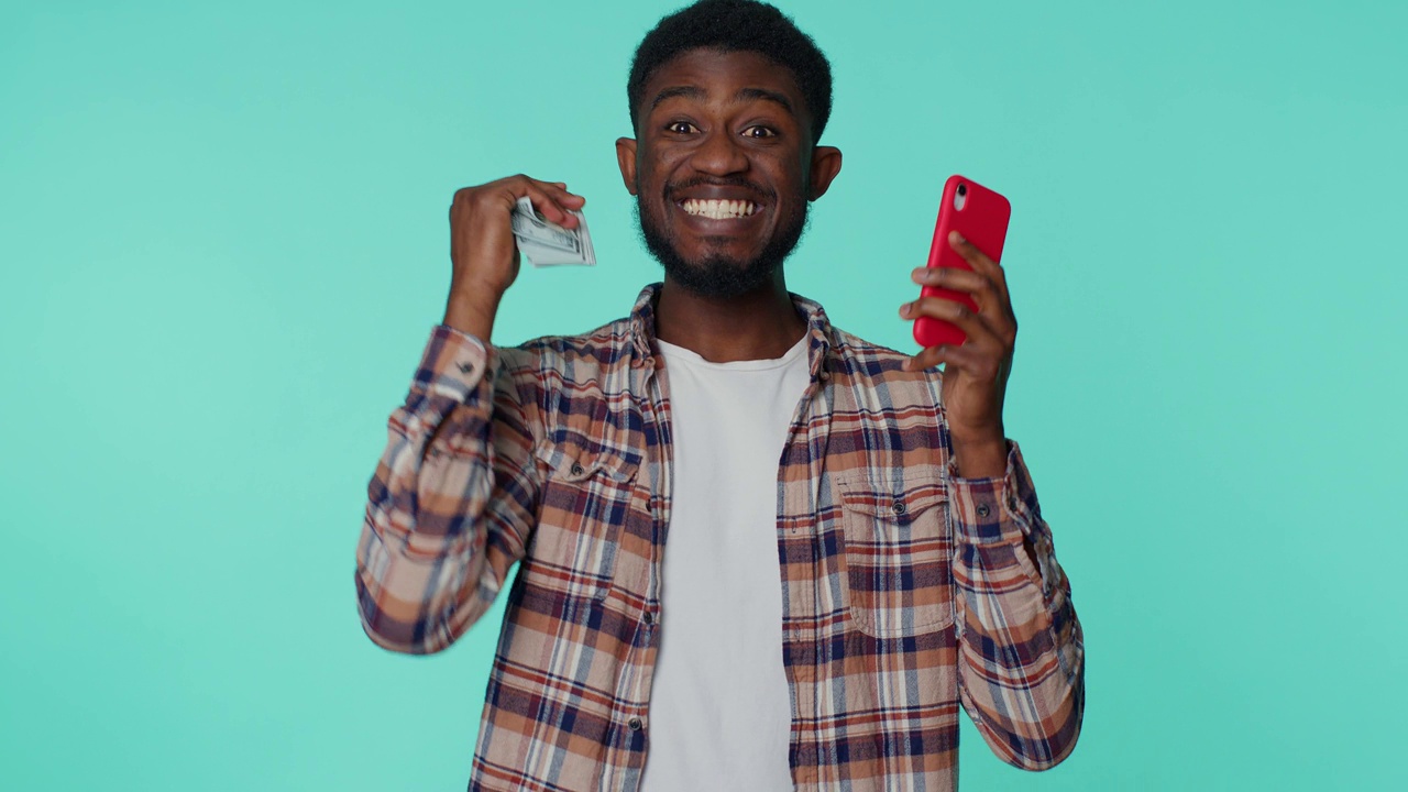 快乐的非裔美国人手机显示真心欢喜赢，收钱美元现金视频素材