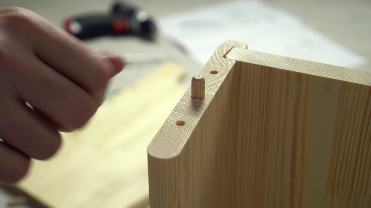 男人用螺栓组装家具螺丝板，双手特写。在家组装木架视频下载