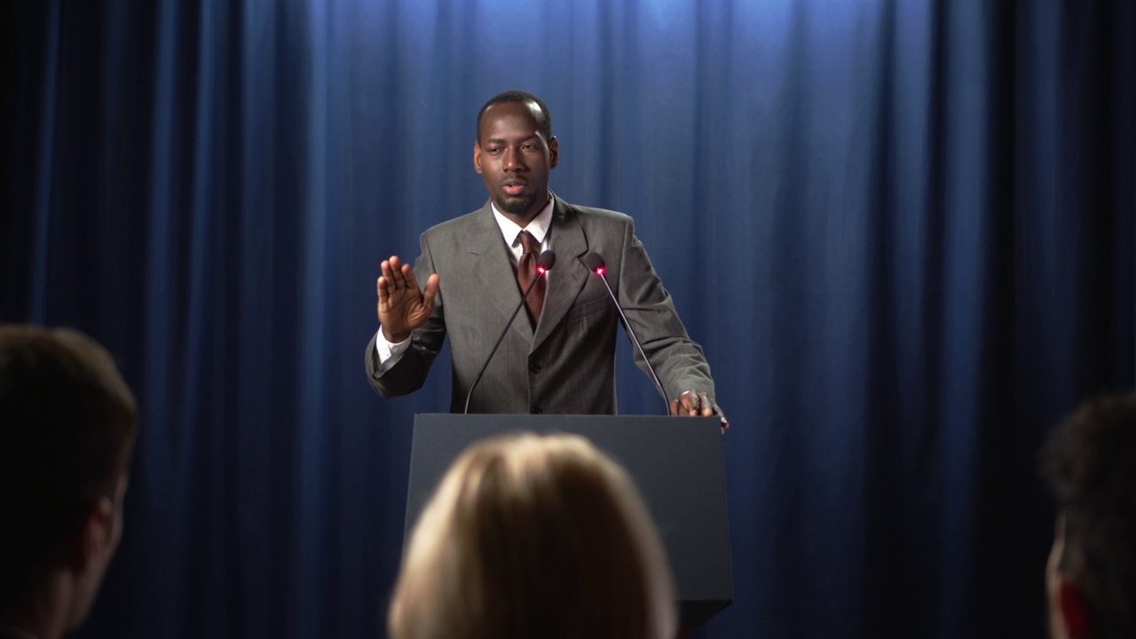 身穿灰色西装的年轻非裔美国政治家在辩论会上情绪激动地发表演讲视频下载