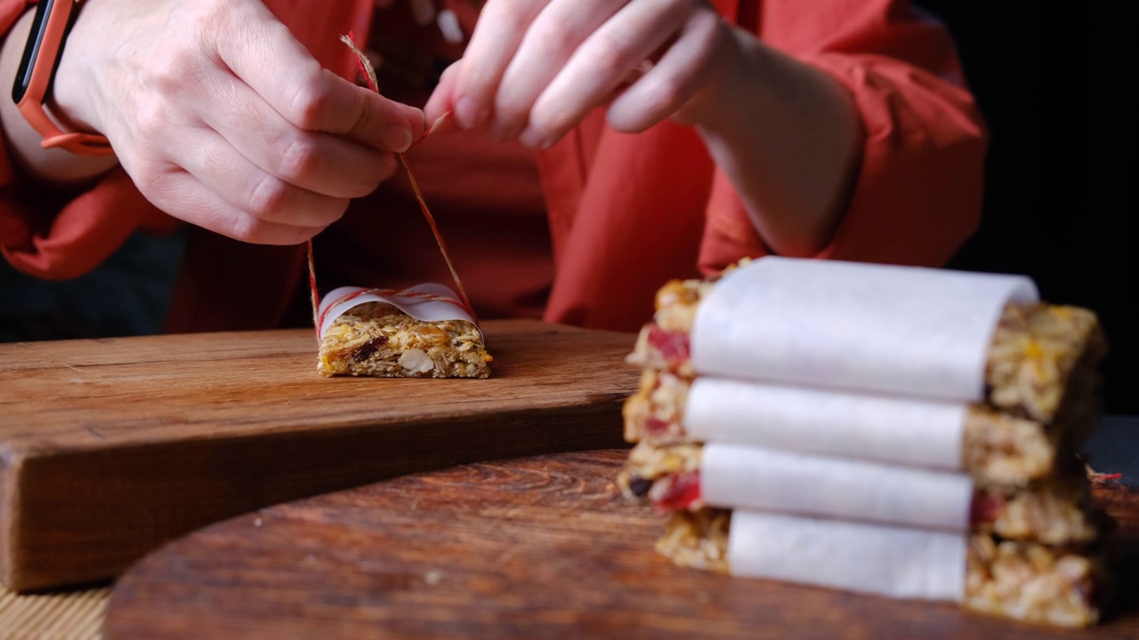 一个女人正在切割和包装自制的格兰诺拉燕麦卷视频下载