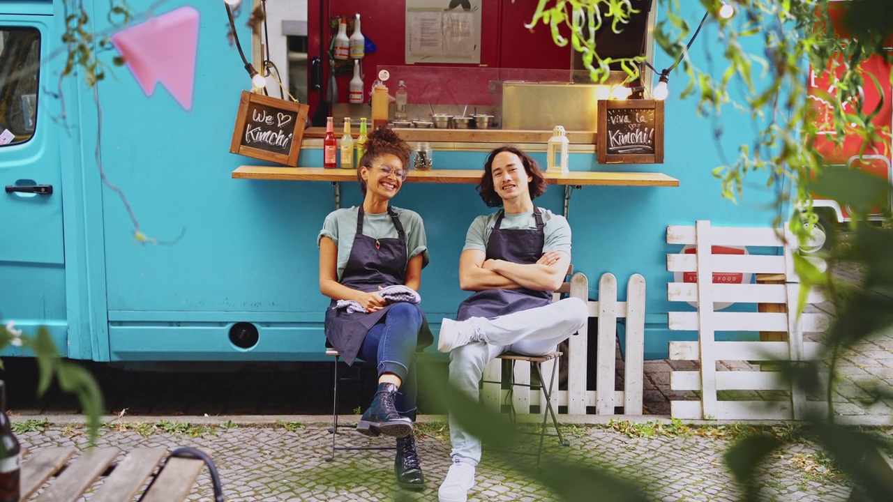 一长串微笑的男女同事坐在蓝色的餐车旁视频下载