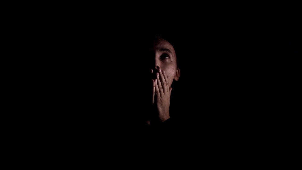 一个忧心忡忡的人坐在黑暗中视频素材