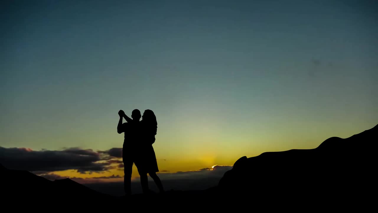 一对恋人的剪影，在金色美丽的夕阳下。视频素材