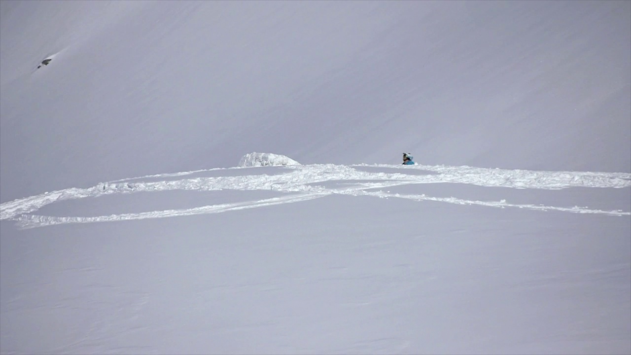 冬天，滑雪者在冰雪覆盖的山上滑雪时，会做后空翻。——慢动作视频下载