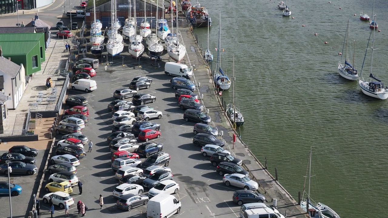 在英国威尔士的卡那封，一个停车场和几艘帆船停泊在Afon Seiont号上。视频下载