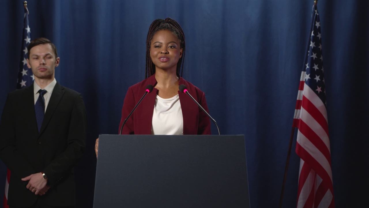 一位身穿红色夹克的年轻黑人女政治家在演讲结束后感谢观众的掌声视频下载