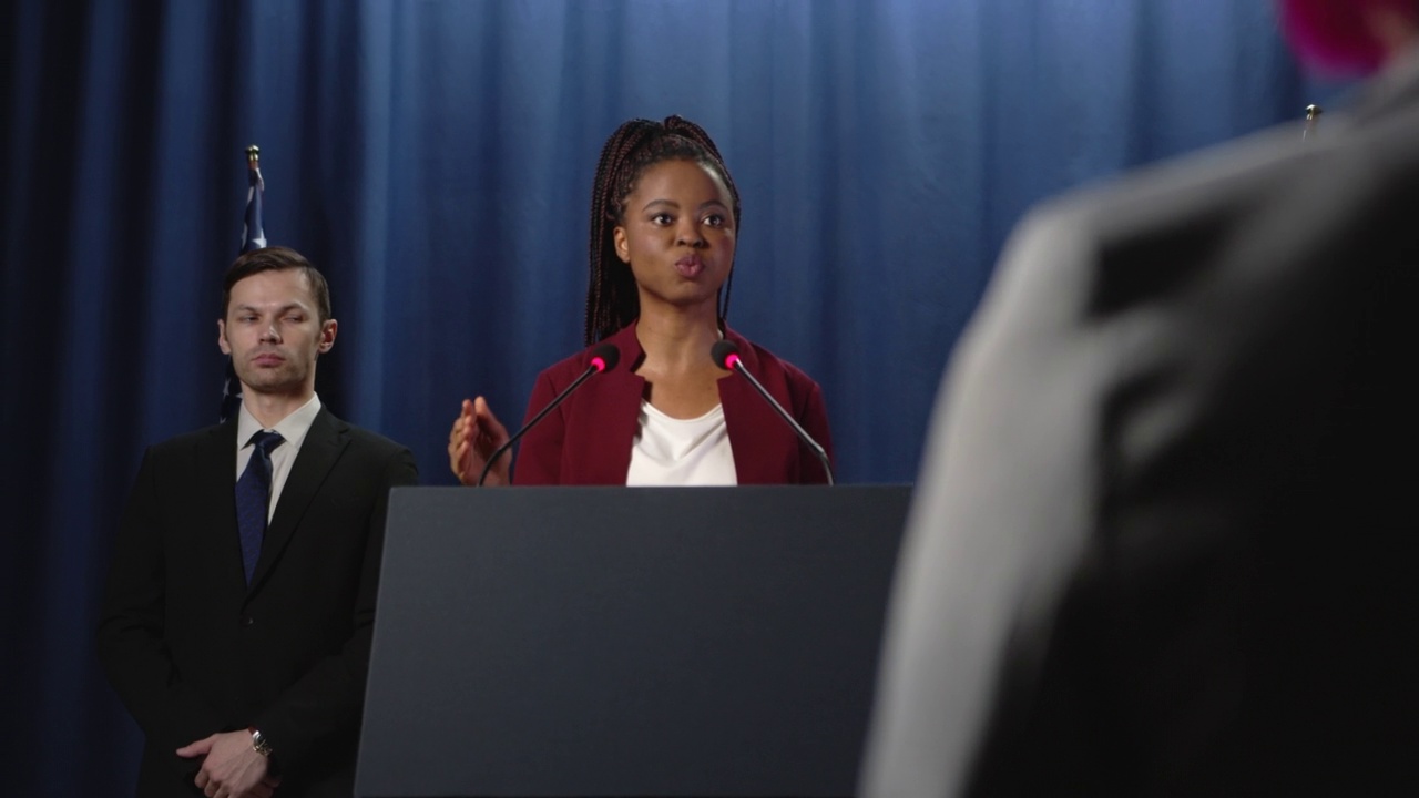 身穿红色夹克的年轻黑人女政治家在摄像机的拍摄下发表了演讲视频下载