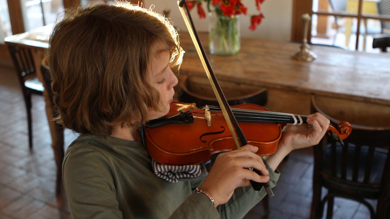 8岁男孩在家里拉小提琴视频素材