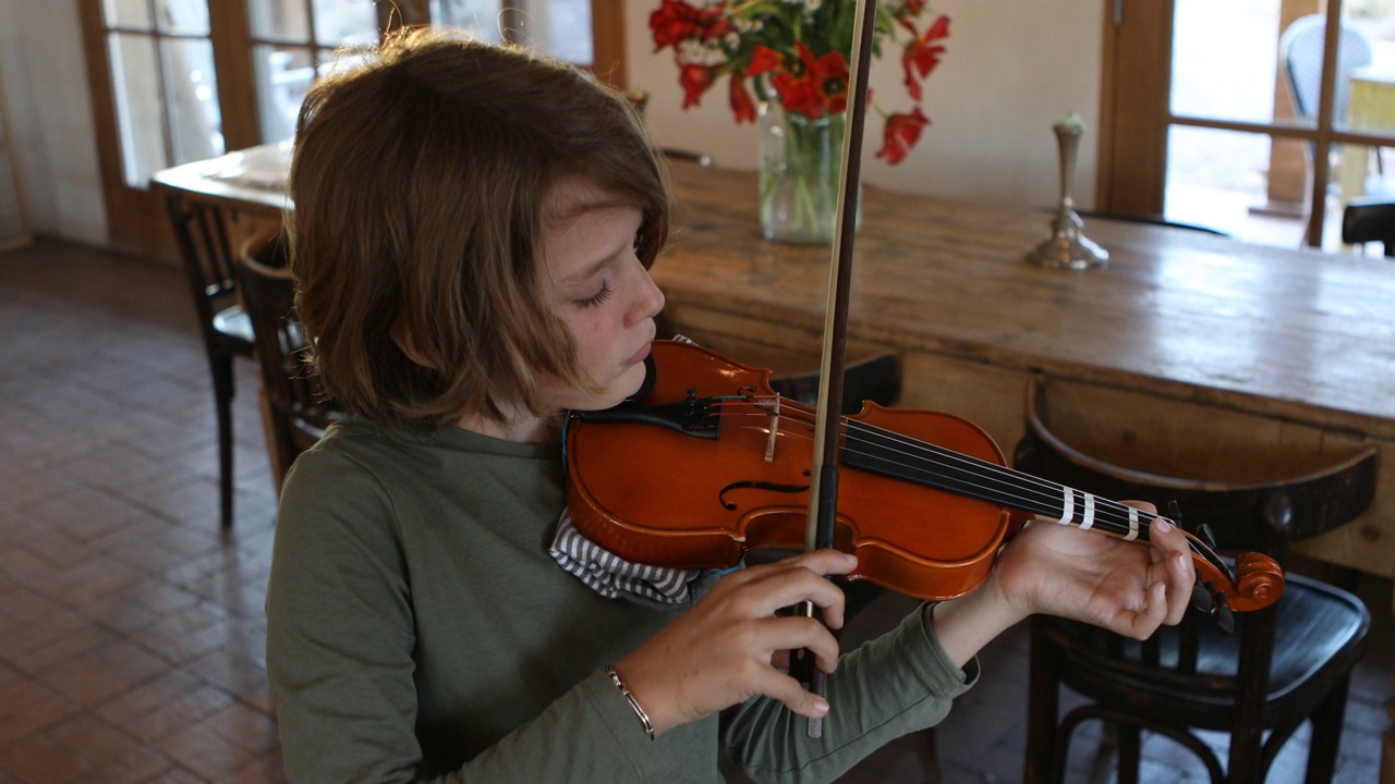 8岁男孩在家里拉小提琴视频素材