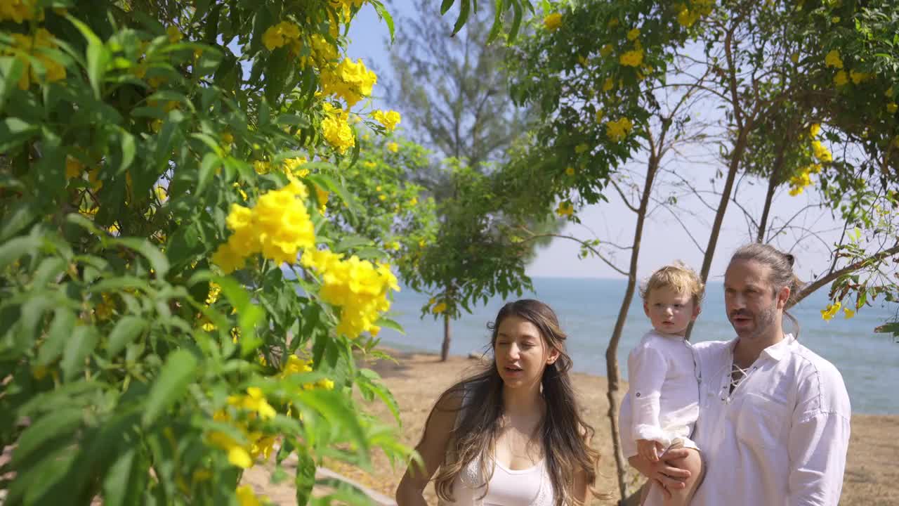 4K白人家庭，带着小宝宝，手牵着手一起走在热带海滩上视频素材