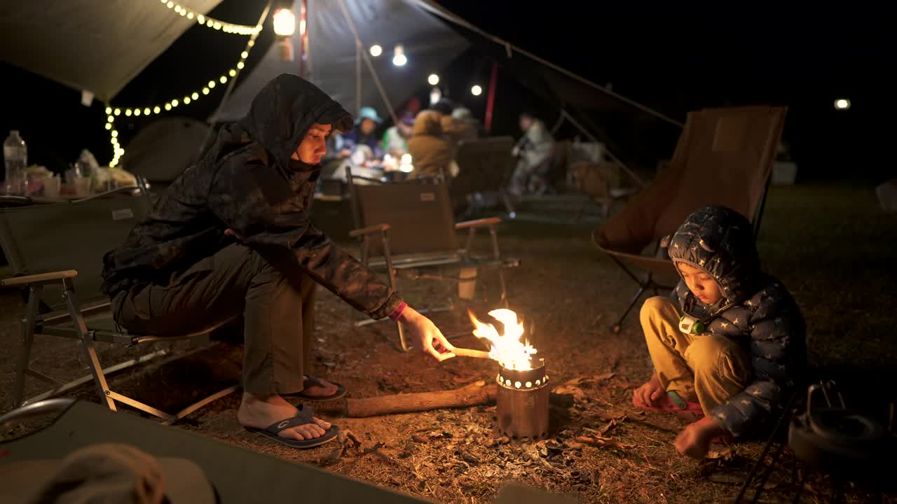 亚洲家庭在露营时坐在篝火旁视频下载