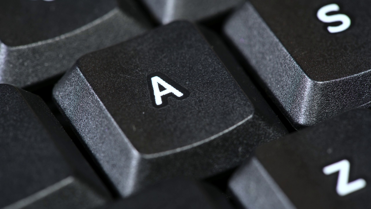 男子按单个字母a键在一个简单的黑色办公室桌面PC电脑键盘，对象细节，宏观，手指极端特写。技术、文字、打字、数字输入抽象概念视频素材
