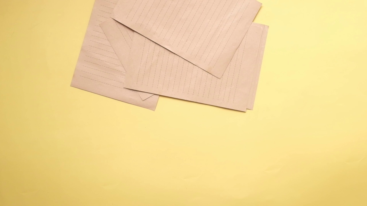 空纸落在黄色背景上的慢动作视频下载