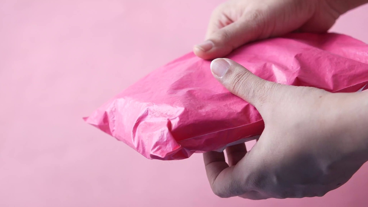 女人们拿着粉红色的包裹视频下载