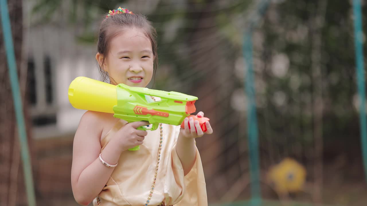 穿着泰国传统服装的孩子们在泼水节玩水枪视频素材