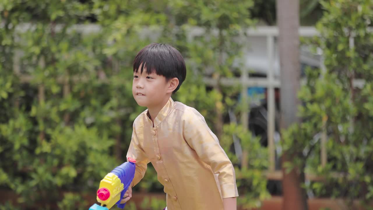 穿着泰国传统服装的孩子们在泼水节玩水枪视频下载