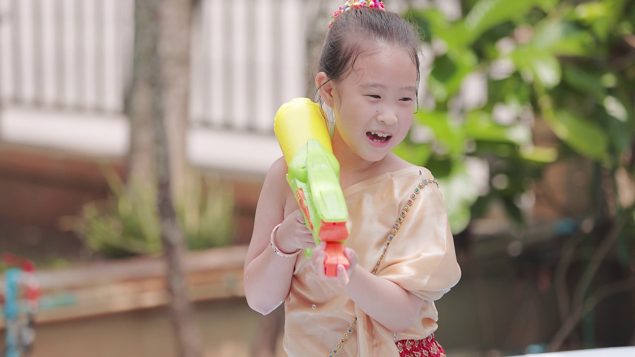 穿着泰国传统服装的孩子们在泼水节玩水枪视频下载
