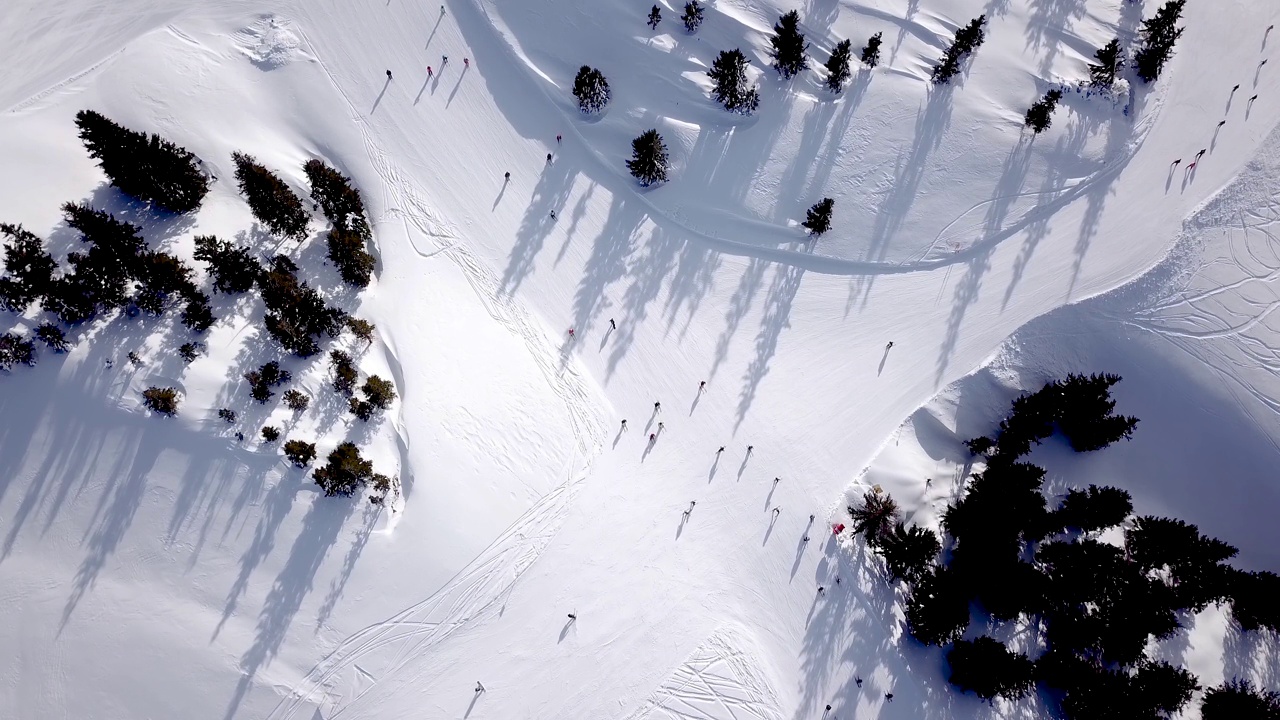 人们在山上滑雪和单板滑雪的鸟瞰图，滑雪胜地。无人机飞过滑雪者视频素材