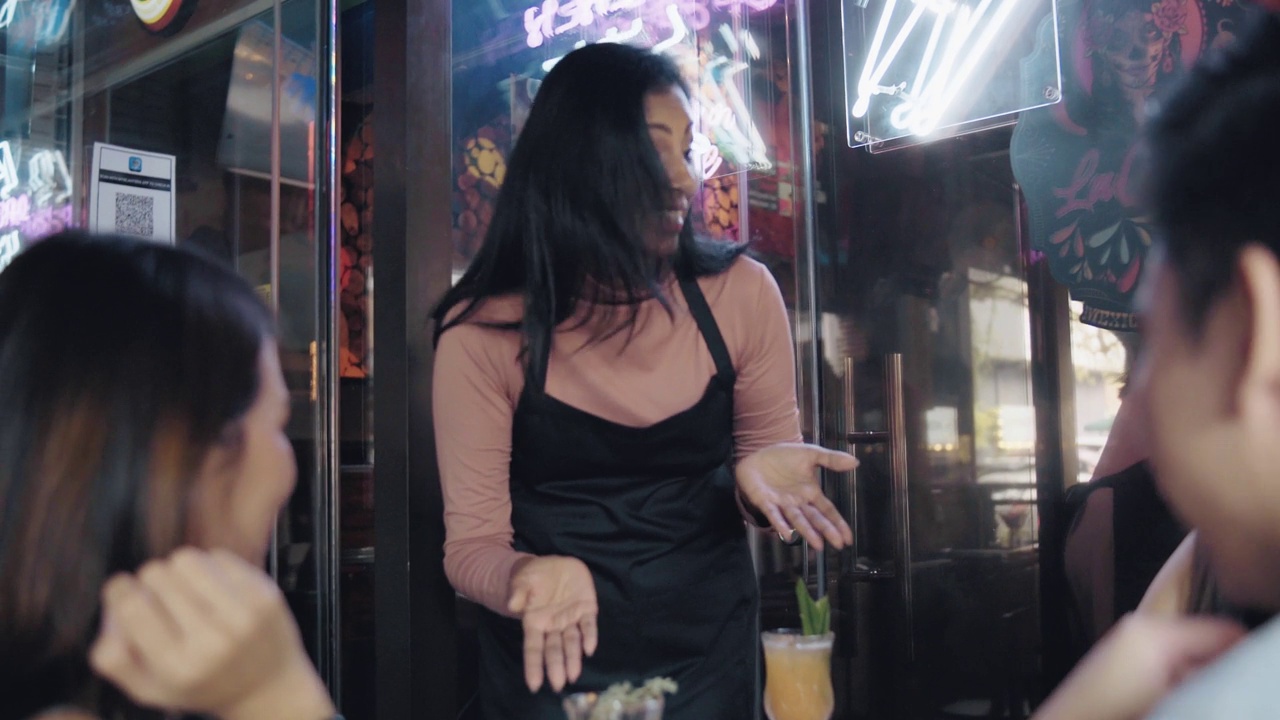 亚洲印度女服务员在酒吧的欢乐时间为她的顾客提供鸡尾酒视频素材