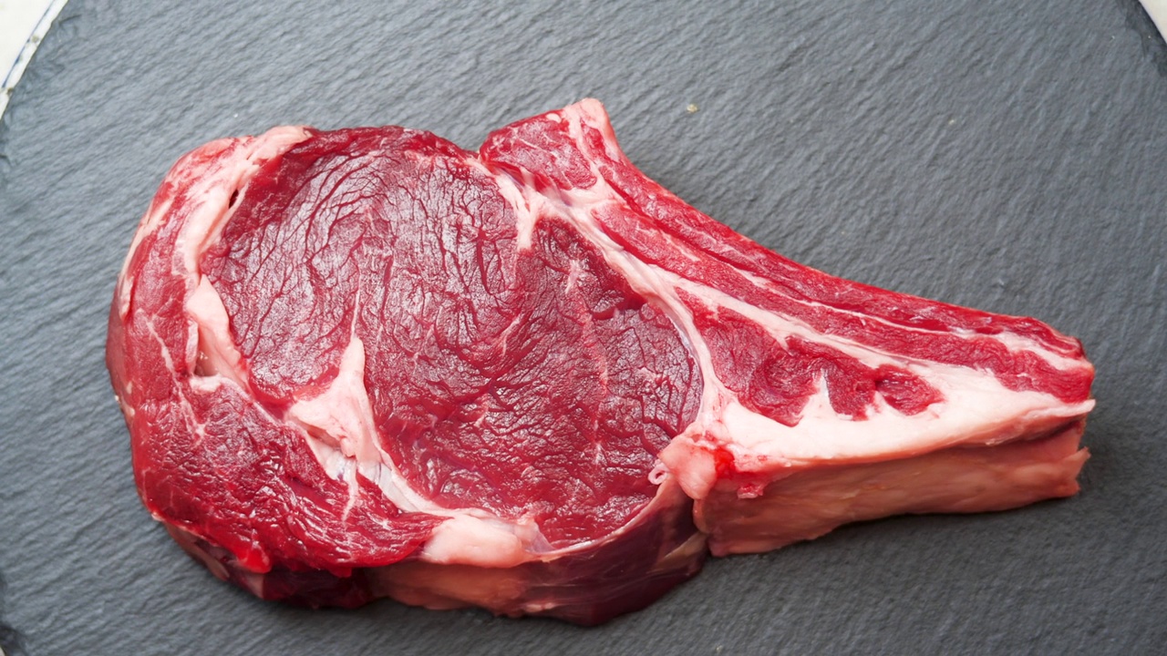 肉旋转背景。生牛肉内脏近距离视频背景。食品的概念。准备把肉烤到骨头上视频素材