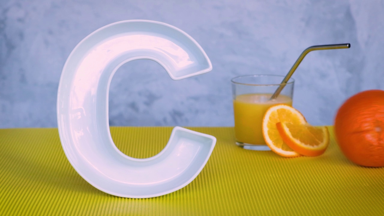维生素C在食品中的概念。字母C形状的盘子，鲜榨的橙汁和滚动的橘子水果。抗坏血酸对免疫系统功能很重要。循环录像。视频下载